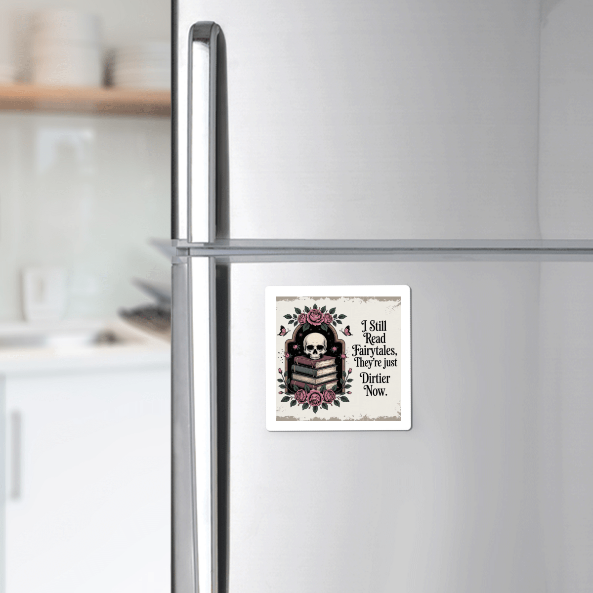 Add a touch of dark whimsy to your kitchen with the Mirabilia Boutique "I Still Read Fairytales" Gothic Book Magnet. Featuring an intricate design of a skull, roses, and books, along with the phrase: "I still read fairytales. They're just dirtier now.", this unique magnet stands out against your refrigerator with blurred kitchen shelves in the background. Perfect as quirky fairytale decor or as a memorable literary gift for book lovers.