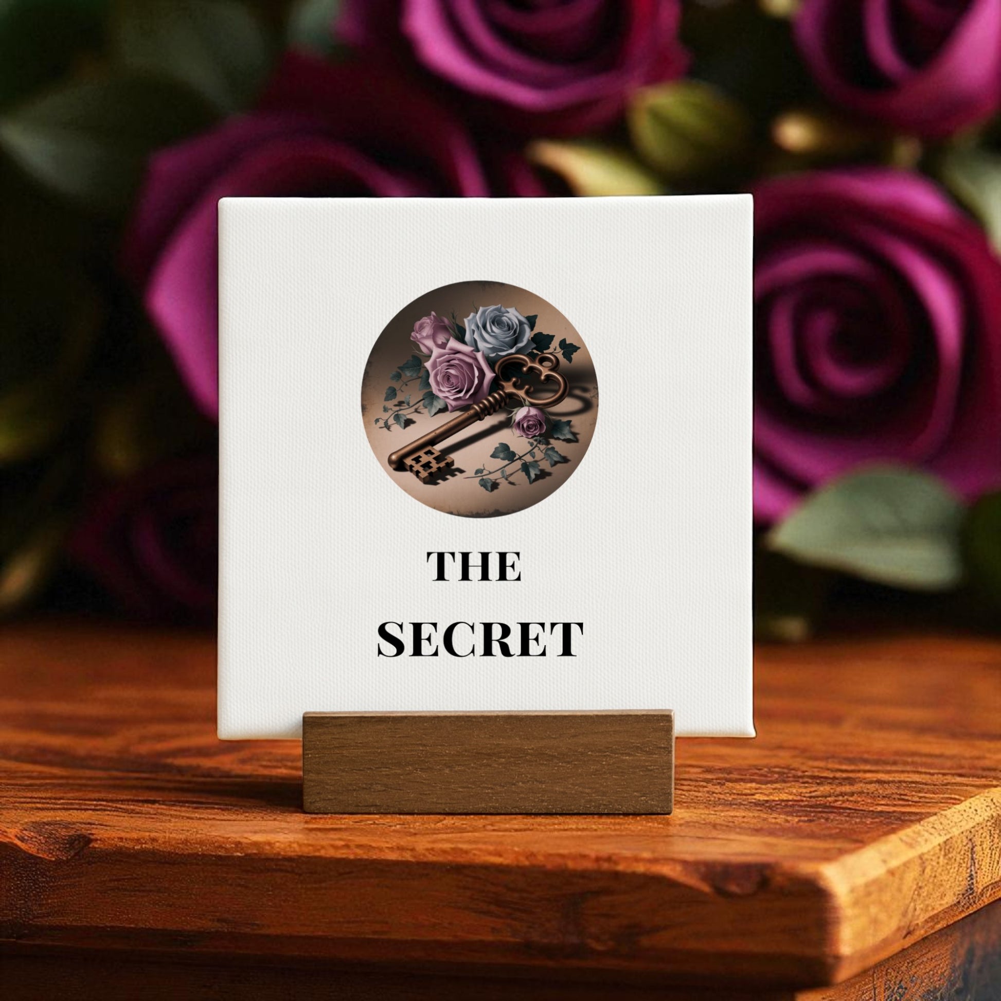 The Mini Gothic Sign | The Secret by Mirabilia Boutique features a rose and vintage key illustration on canvas with "THE SECRET" text, set on a wooden stand—ideal Dead Regency decor for regencycore home styling.