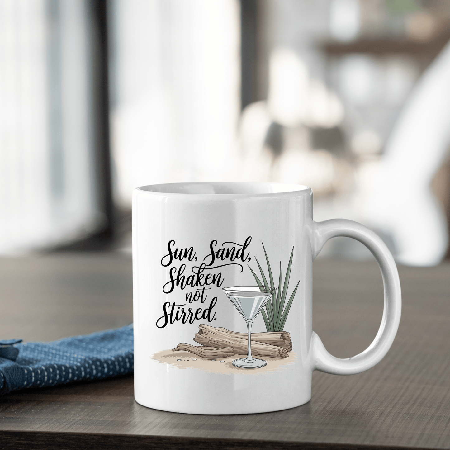 The Sun, Sand, Shaken Not Stirred Mug – Coastal Coffee Vibe by Mirabilia Boutique features a martini glass, driftwood, and grass design with the phrase “Sun, Sand, Shaken not Stirred,” perfect for adding beach house charm.