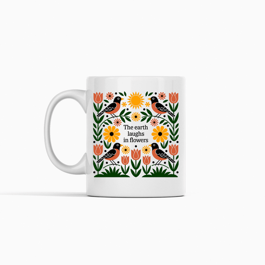 The Earth Laughs in Flowers Spring Mug by Mirabilia Boutique features vibrant flowers, birds, and green leaves with the quote "The earth laughs in flowers"—a perfect gift for nature lovers.