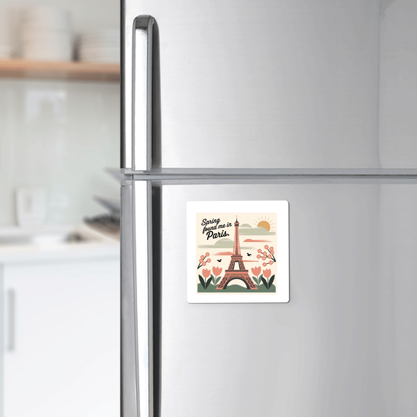 A silver fridge adorned with Mirabilia Boutique’s “Spring Found Me in Paris Magnet – Eiffel Tower Charm” brings a touch of Parisian spring to your kitchen with its charming Eiffel Tower and floral design.