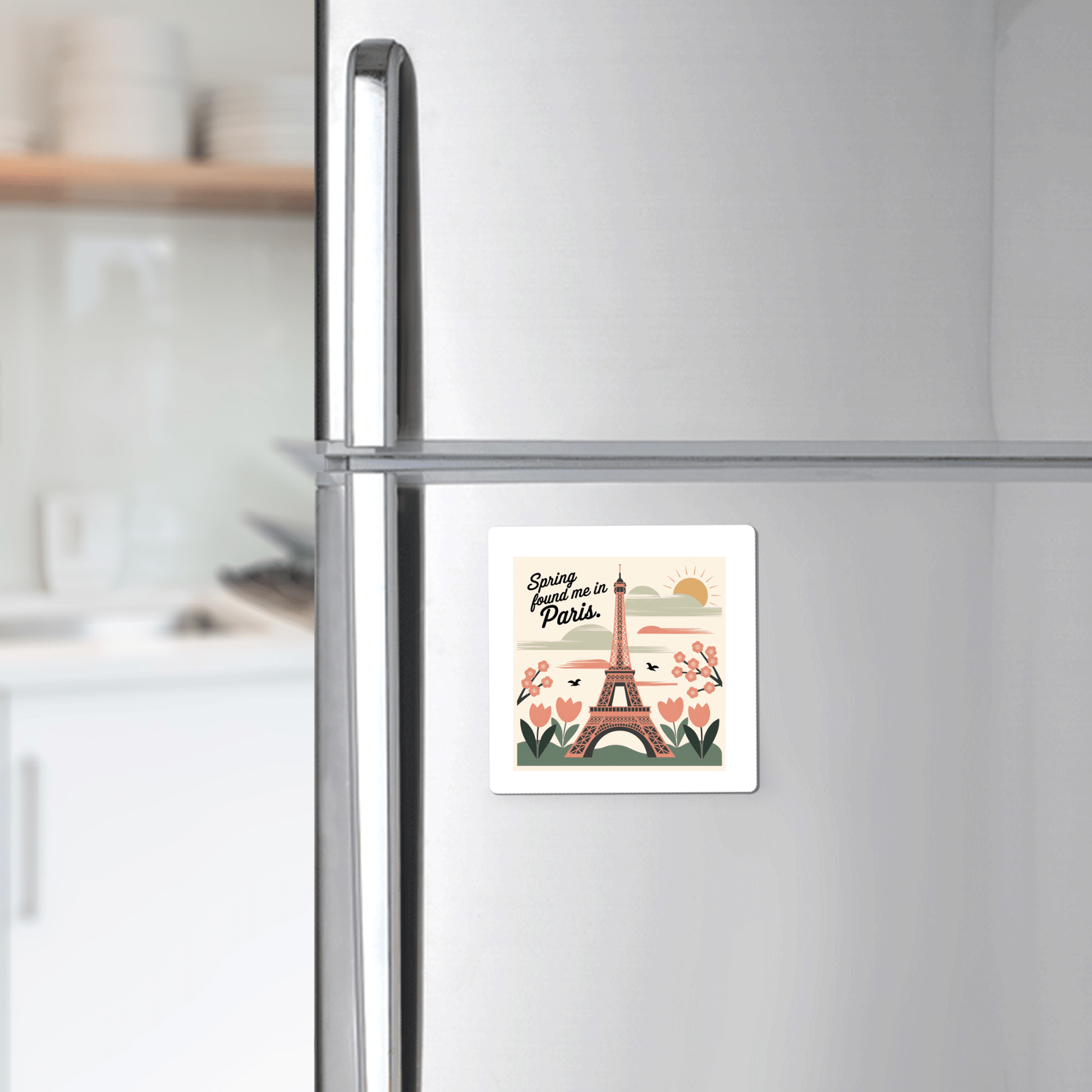 A silver fridge adorned with Mirabilia Boutique’s “Spring Found Me in Paris Magnet – Eiffel Tower Charm” brings a touch of Parisian spring to your kitchen with its charming Eiffel Tower and floral design.