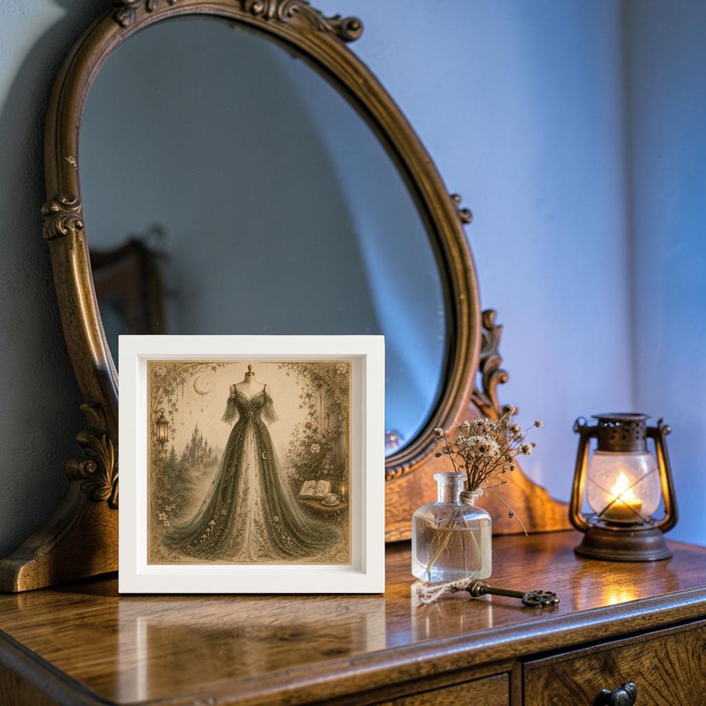 A framed piece of "Moonlit Sanctuary | Curated Couture Artwork" by Mirabilia Boutique rests on a vintage wooden dresser with a curved mirror, accompanied by dried flowers in a bottle, an old key, and a lit lantern, evoking a cozy and nostalgic atmosphere.