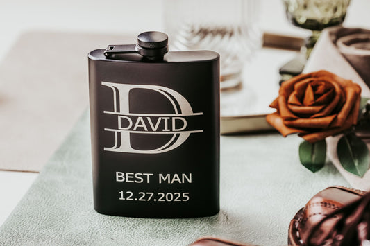 The Personalized Best Man Flask Gift Set by Mirabilia Boutique features a custom black flask engraved with "D," "DAVID," and "BEST MAN 12.27.2025." A stylish groomsmen present, it comes with accessories, ideal for your wedding party.