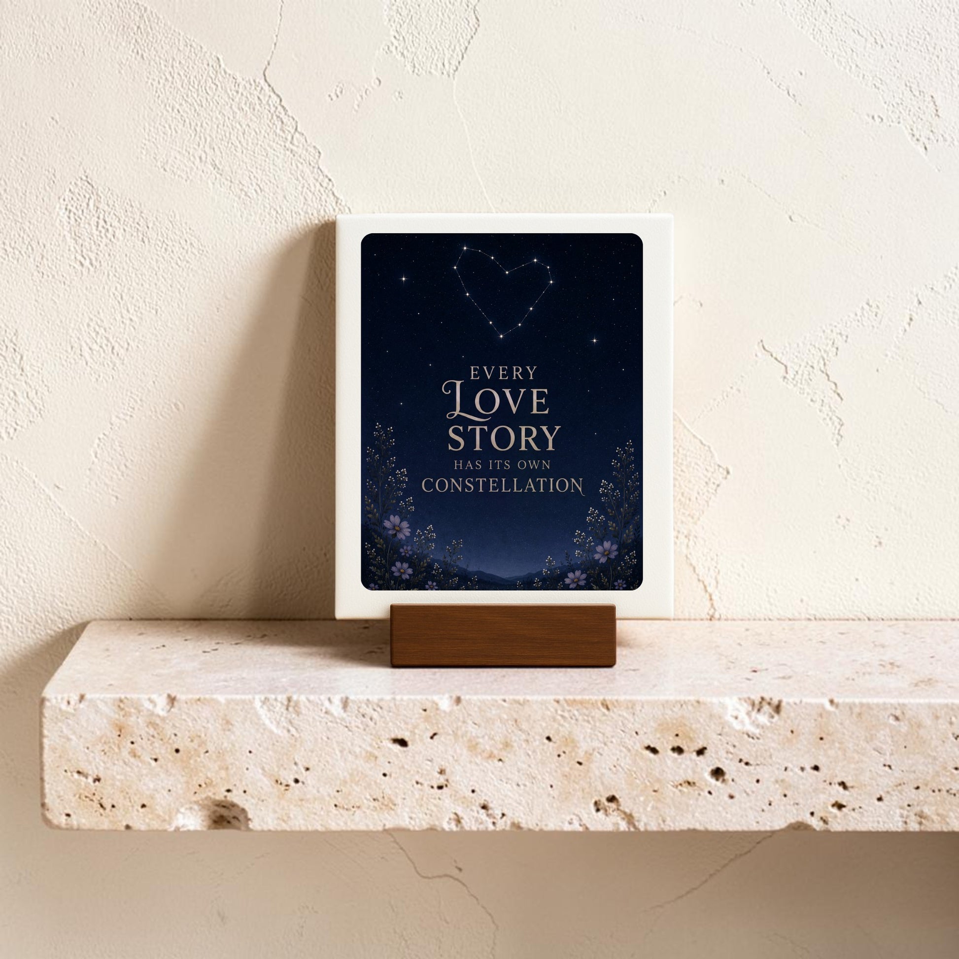 A mini sign from Mirabilia Boutique’s Every Love Story Constellation collection rests on a stone shelf, featuring celestial decor—a heart-shaped constellation shining above the phrase, “Every love story has its own constellation.”.