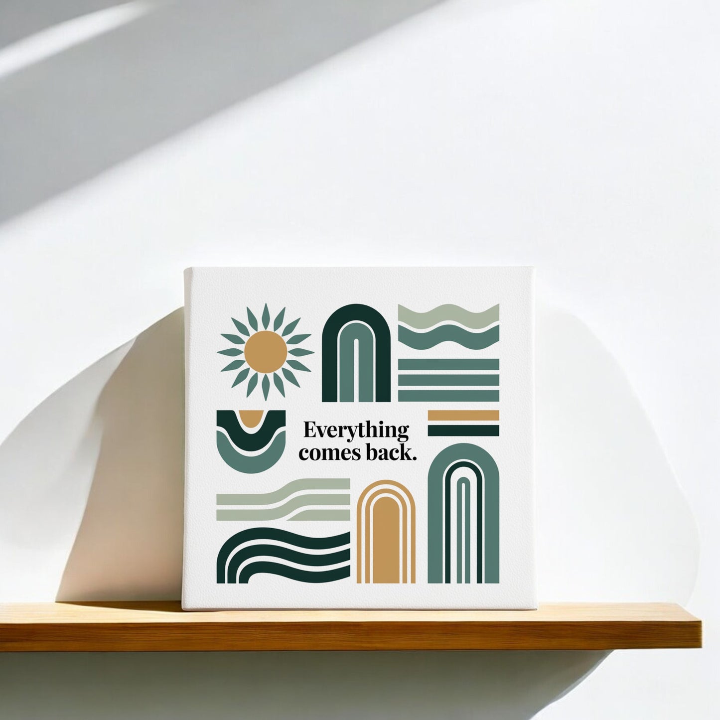 The Mirabilia Boutique "Everything Comes Back Canvas – Earth Tone Wall Art" is an 8x8 modern abstract piece with geometric shapes and a sun, displayed on a wooden shelf against a softly lit white wall.