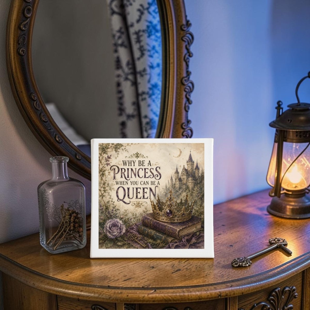 The "Why Be a Princess When You Can Be a Queen Canvas" by Mirabilia Boutique adds empowering charm to your space, featuring bold fairytale-inspired wall art displayed on a wooden vanity beside a lantern, key, and glass bottle with dried flowers, with a mirror reflecting its uplifting message—perfect for creating an inspiring atmosphere.