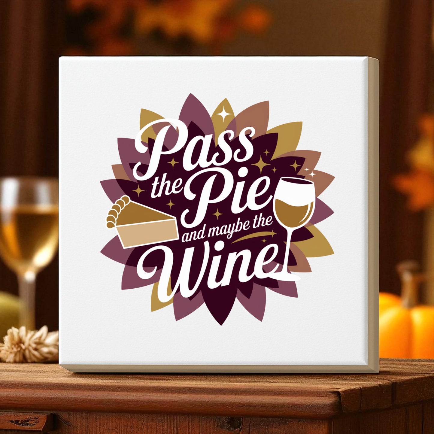 The Pass the Pie and Maybe the Wine Canvas Sign by Mirabilia Boutique features a pie slice, wine glass, and its witty saying on a layered autumn flower background—funny Thanksgiving decor for your home.