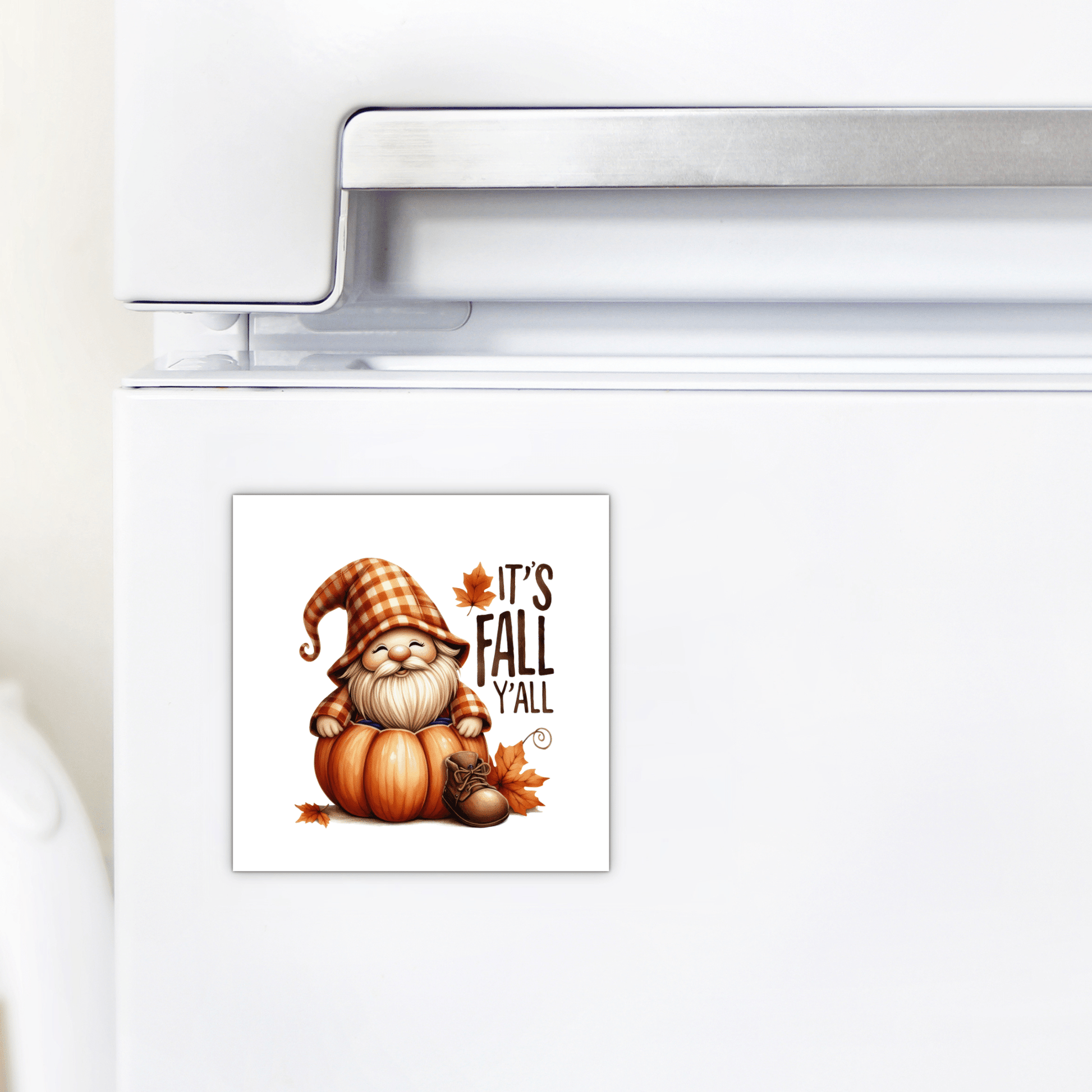 Display the Mirabilia Boutique Fall Gnome Magnet—"It's Fall Y'all"—on your fridge. This autumn decor shows a gnome in a plaid hat sitting on a pumpkin, with fall leaves, adding charm to your farmhouse kitchen.