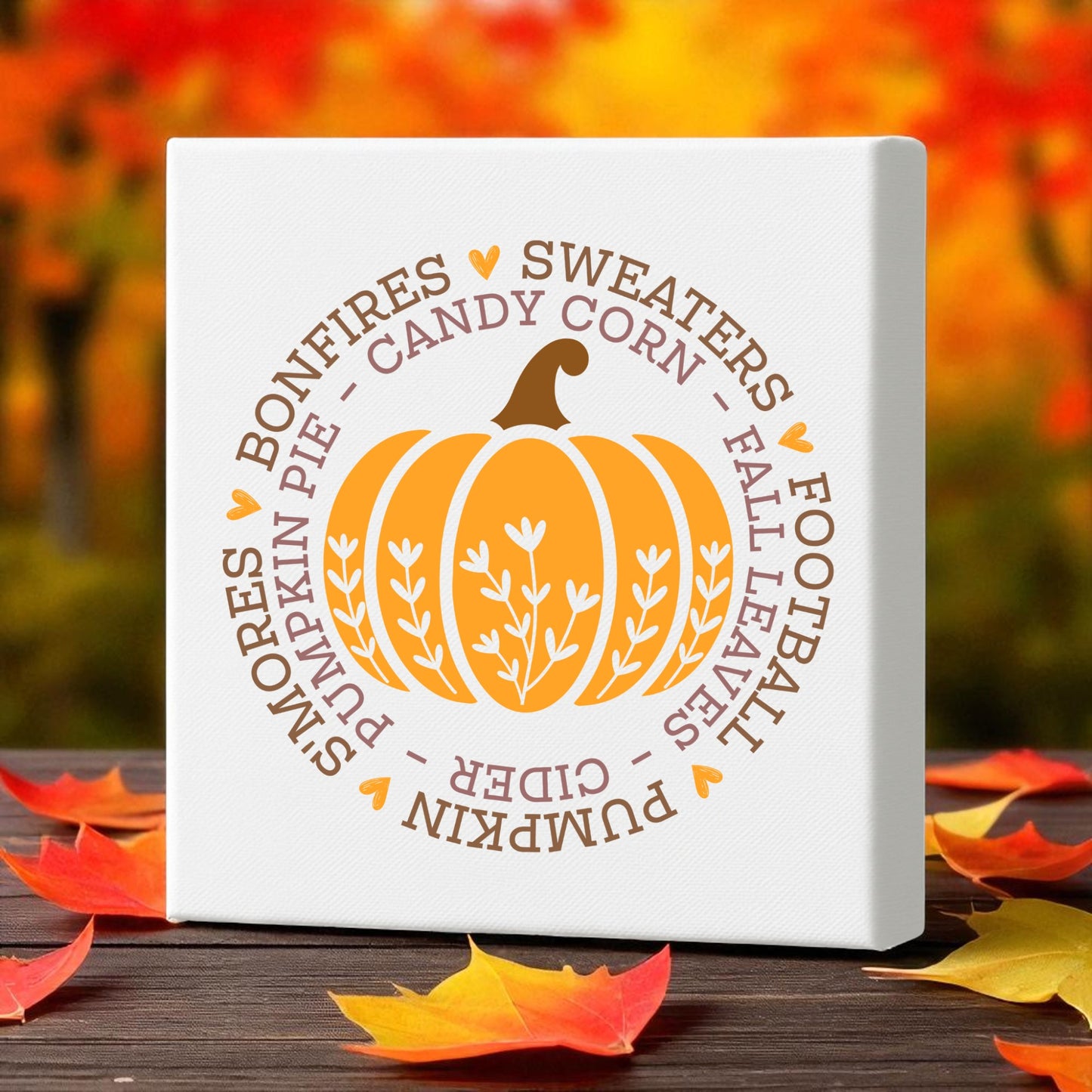 The Fall Pumpkin Canvas by Mirabilia Boutique adds cozy autumn vibes with its orange pumpkin, words like “bonfires” and “pumpkin pie,” and a backdrop of fall foliage. This 8x8 wall art makes perfect seasonal decor for any space.
