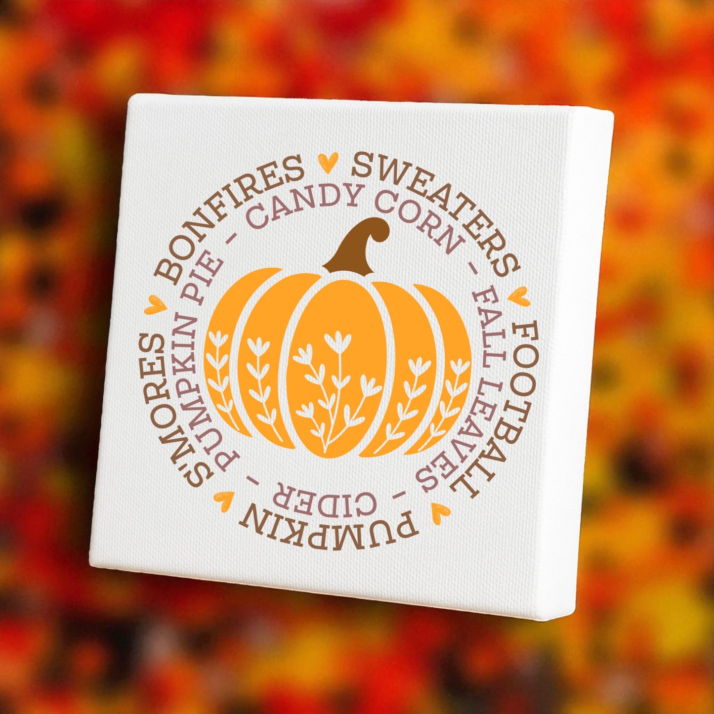 The Fall Pumpkin Canvas by Mirabilia Boutique features an orange pumpkin and fall-themed words, making it perfect 8x8 wall art for cozy autumn decor in your home.