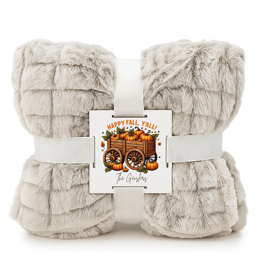The Mirabilia Boutique Custom Fall Throw Blanket, a soft light gray faux fur, comes folded with a white ribbon and card reading "Happy Fall, Y'all!" and "The Goshers"—a cozy autumn gift for any home.