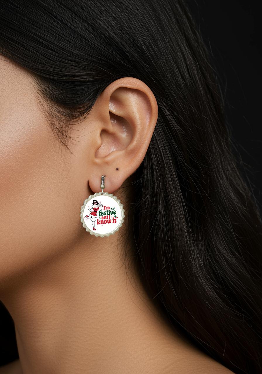 Close-up of a woman wearing Mirabilia Boutique's "Festive and I Know It Earrings"—retro holiday style with a red hat and playful text. The earrings pop against a white background, complemented by her long, dark hair and smooth skin.