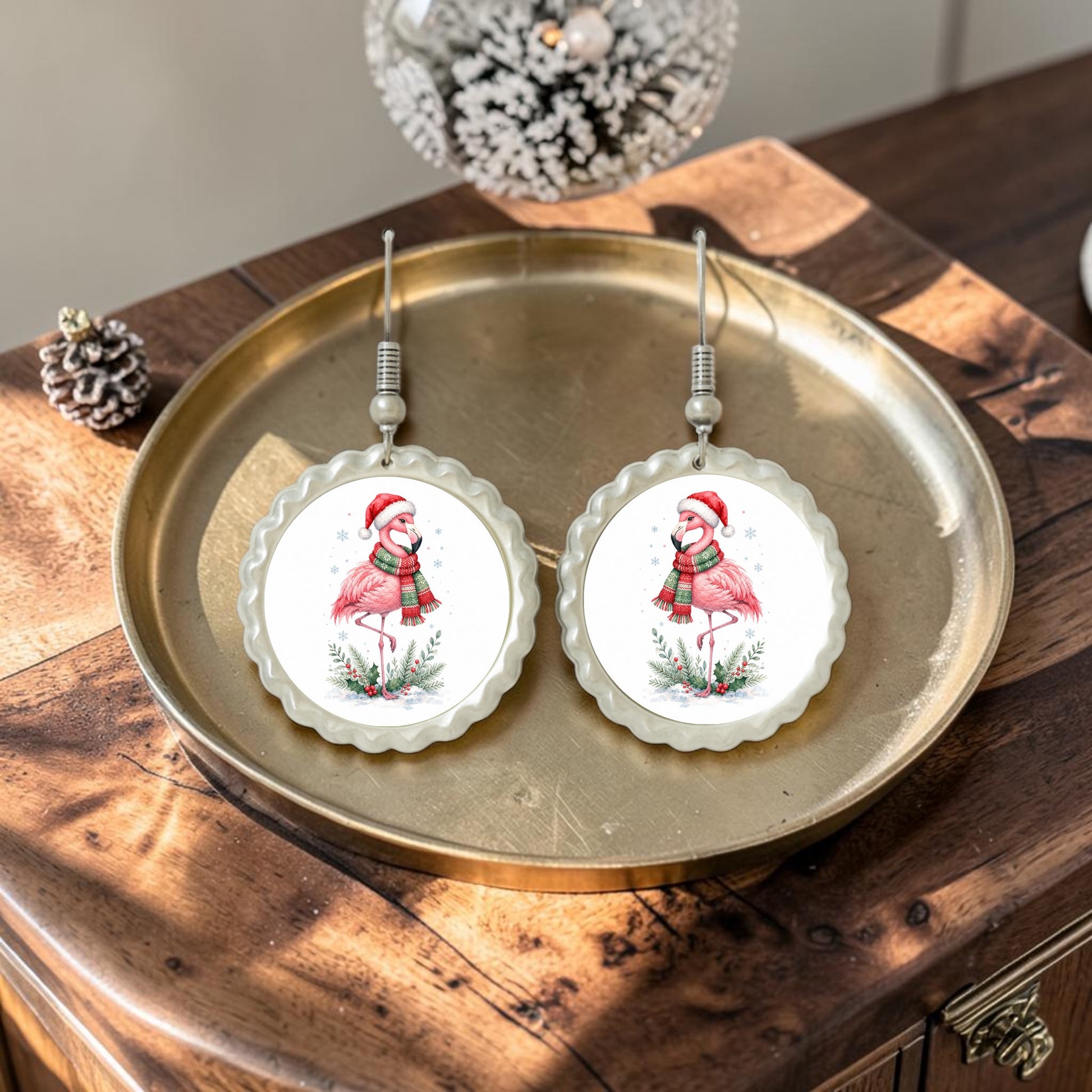 Add a whimsical flair to your holiday look with the Festive Flamingo Earrings | Winter Bird Jewelry by Mirabilia Boutique. These handcrafted earrings feature charming illustrations of flamingos wearing Santa hats and scarves, making them the perfect Christmas accessory. Displayed on a brass tray atop a wooden table accented with festive decor, these playful pieces are sure to brighten any winter ensemble.