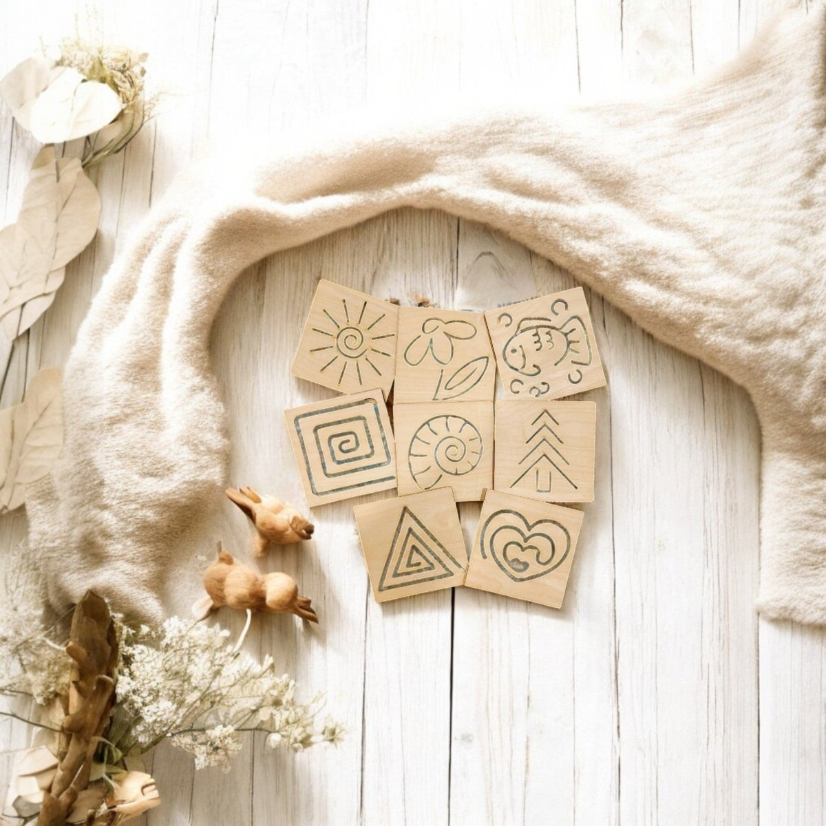 The Mirabilia Boutique Montessori Style Tracing Boards Set of 8—perfect for building pre-writing skills and fine motor control—are displayed on a white wooden surface with fabric, dried flowers, and small wooden rabbits.