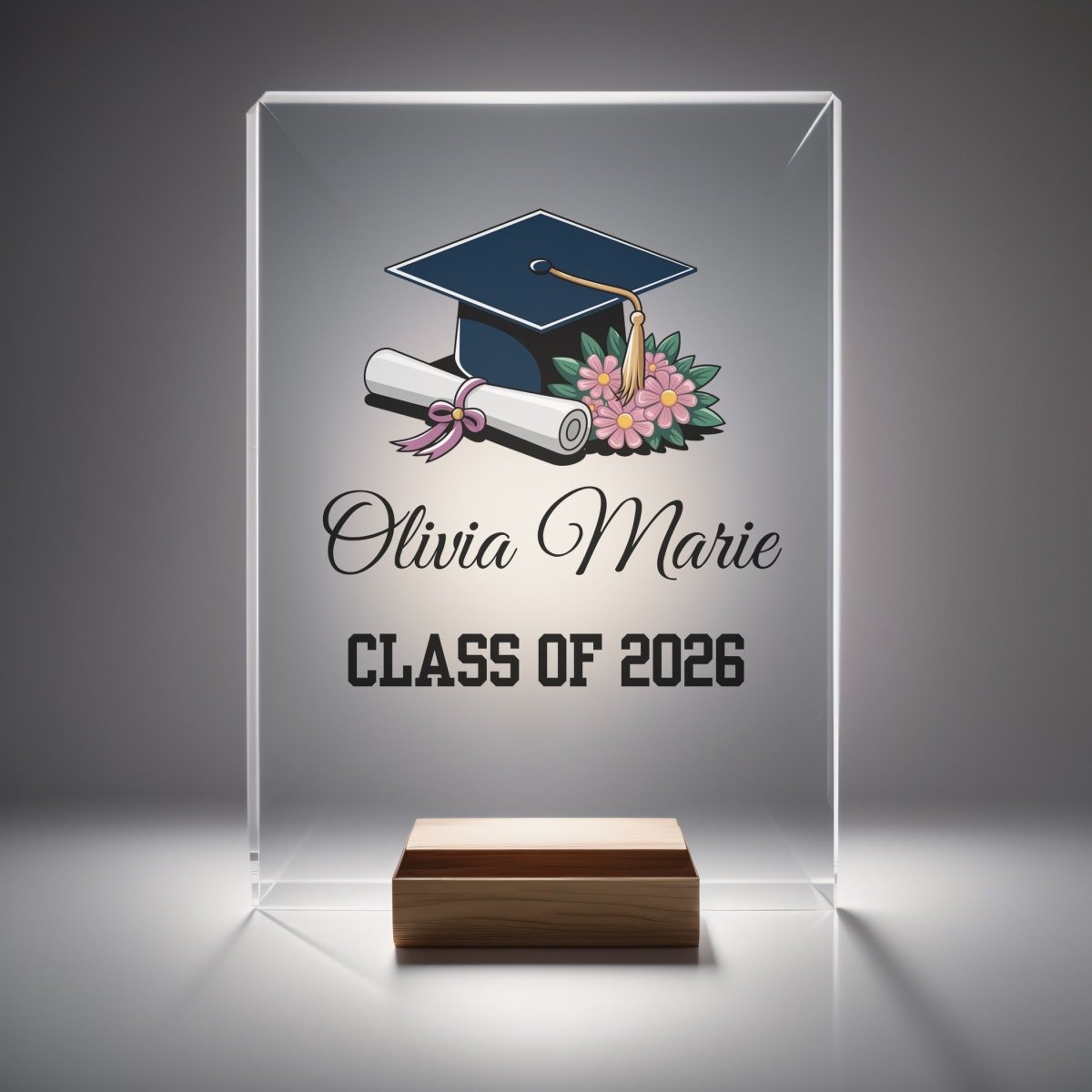 The Mirabilia Boutique Floral Personalized Graduation Night Light displays "Olivia Marie" and "Class of 2026" with a cap, diploma, and flowers on a wooden base, making a unique graduation keepsake.