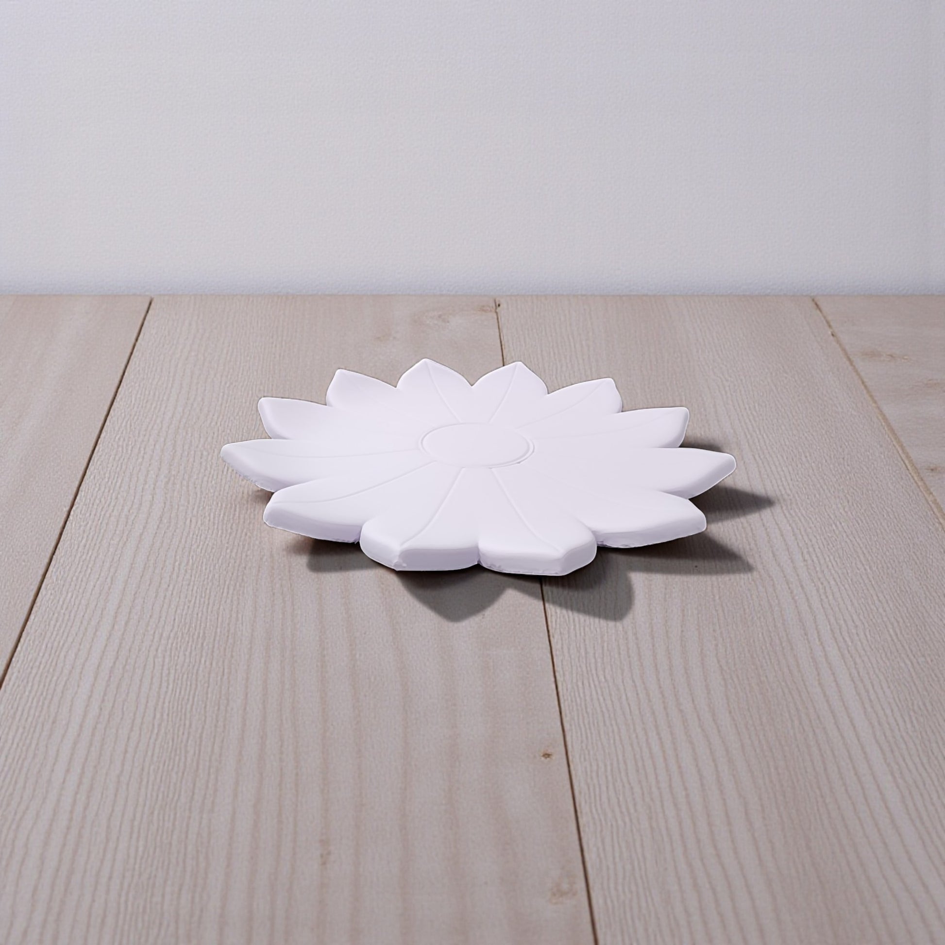 The Spring Bloom Tray by Mirabilia Boutique, a delicate floral accent in white, rests on a light wooden surface with a simple, light-colored backdrop.