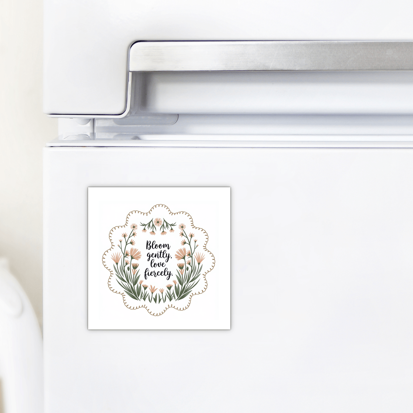 The Bloom Gently Love Fiercely Floral Magnet by Mirabilia Boutique features wildflowers and the quote “Bloom gently, love fiercely” on a square design perfect for your fridge.