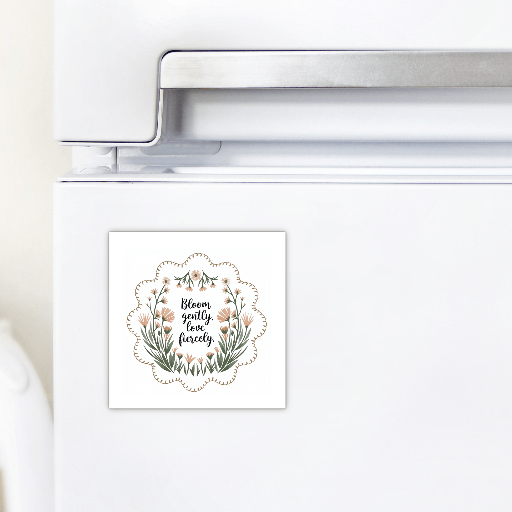 The Bloom Gently Love Fiercely Floral Magnet by Mirabilia Boutique features wildflowers and the quote “Bloom gently, love fiercely” on a square design perfect for your fridge.