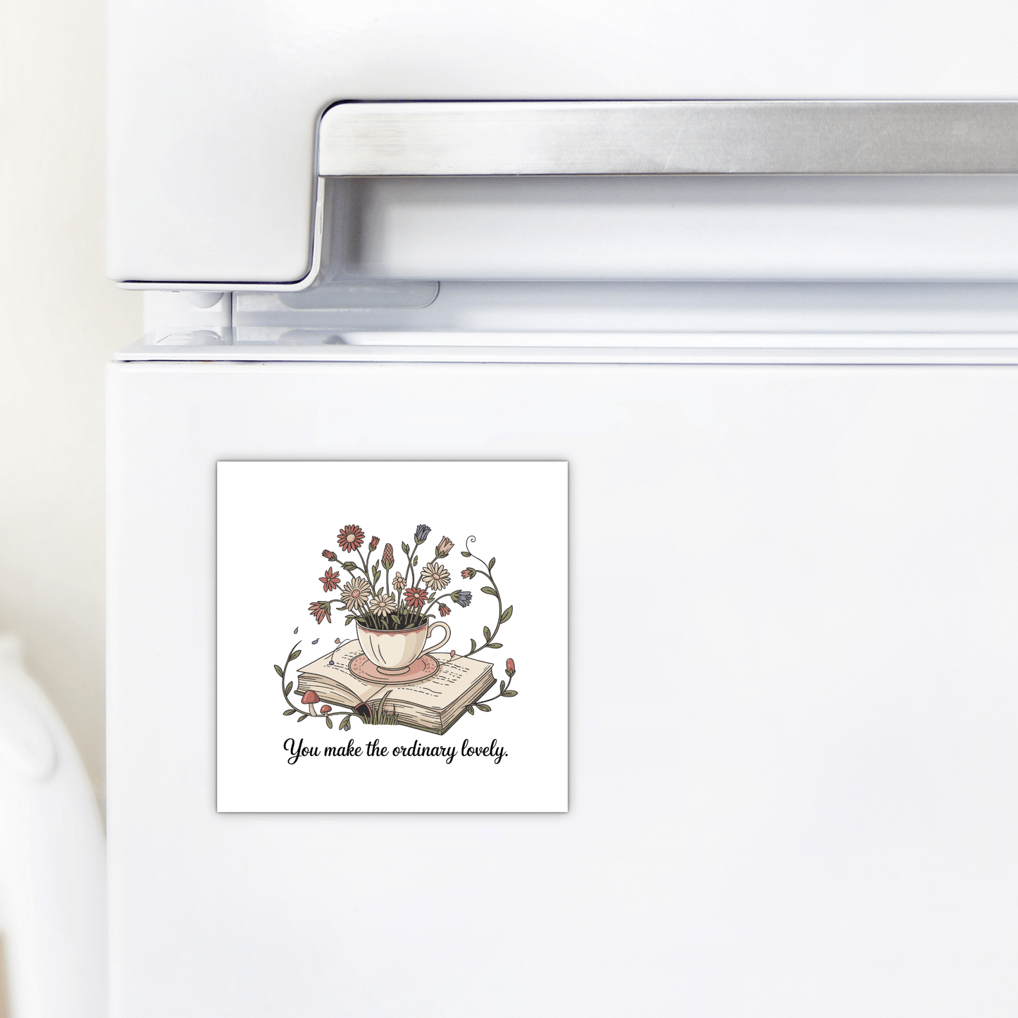 The Floral Teacup Book Magnet by Mirabilia Boutique features a teacup with flowers and books and the phrase “You Make the Ordinary Lovely”—a lovely, inspirational gift to brighten any kitchen fridge.