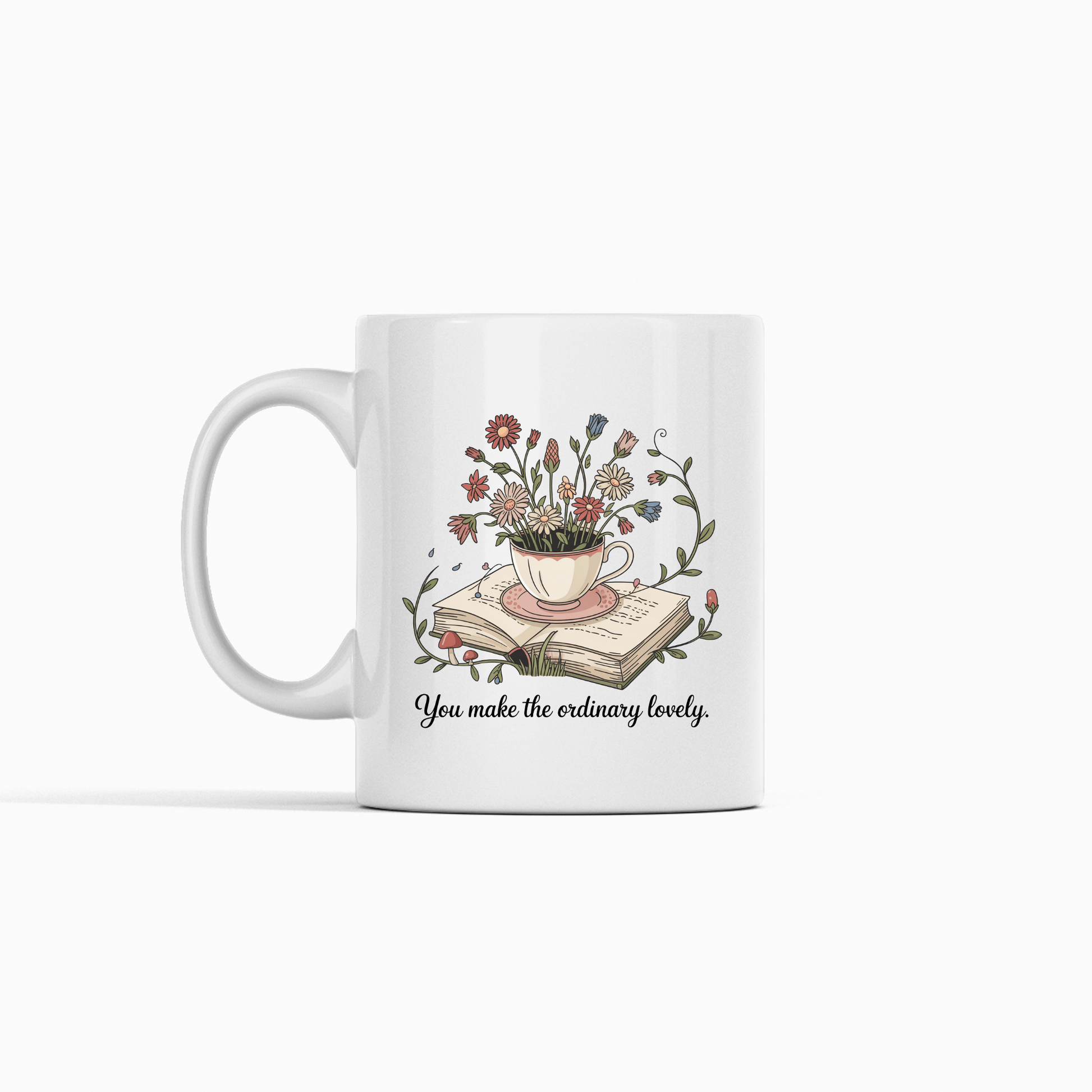 The "You Make The Ordinary Lovely | Floral Teacup Mug" by Mirabilia Boutique features a floral teacup with wildflowers atop books and the quote “You make the ordinary lovely”—a delightful gift for book lovers.