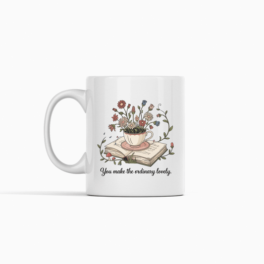 The "You Make The Ordinary Lovely | Floral Teacup Mug" by Mirabilia Boutique features a floral teacup with wildflowers atop books and the quote “You make the ordinary lovely”—a delightful gift for book lovers.