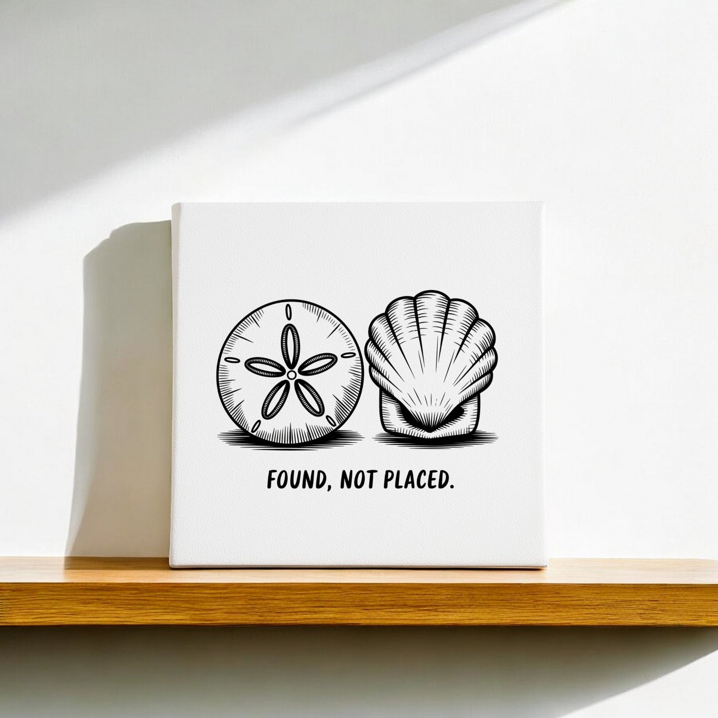 The Found, Not Placed Canvas – Coastal Sketch Wall Art by Mirabilia Boutique features minimalist black and white sand dollar and seashell illustrations with the phrase "FOUND, NOT PLACED," perfect for adding a touch of beach style to your space.