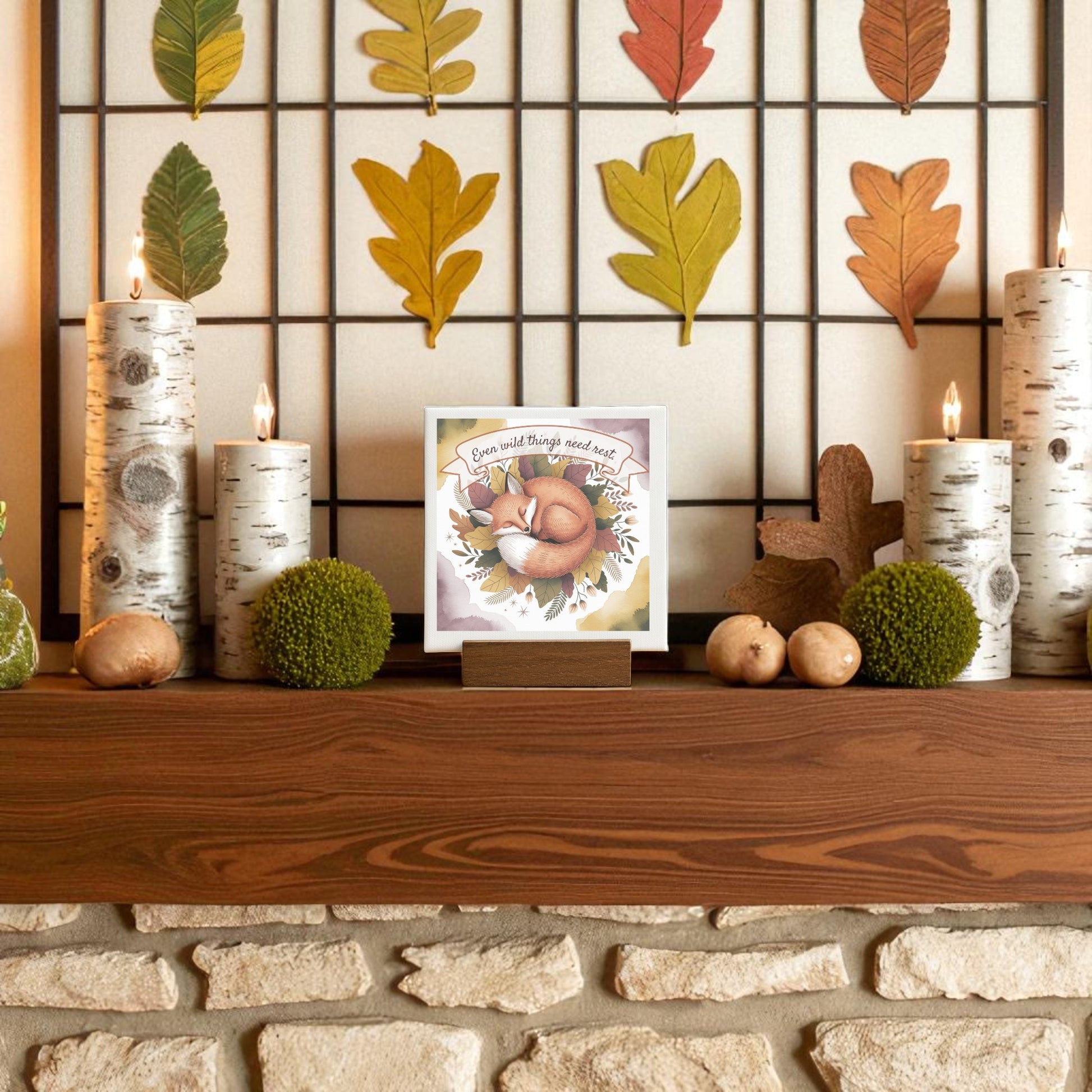 A wooden mantel adorned with birch candles, green moss balls, and autumn cards makes the perfect setting for displaying Mirabilia Boutique’s Fox Nature Art Print featuring the “Even Wild Things Need Rest” quote.
