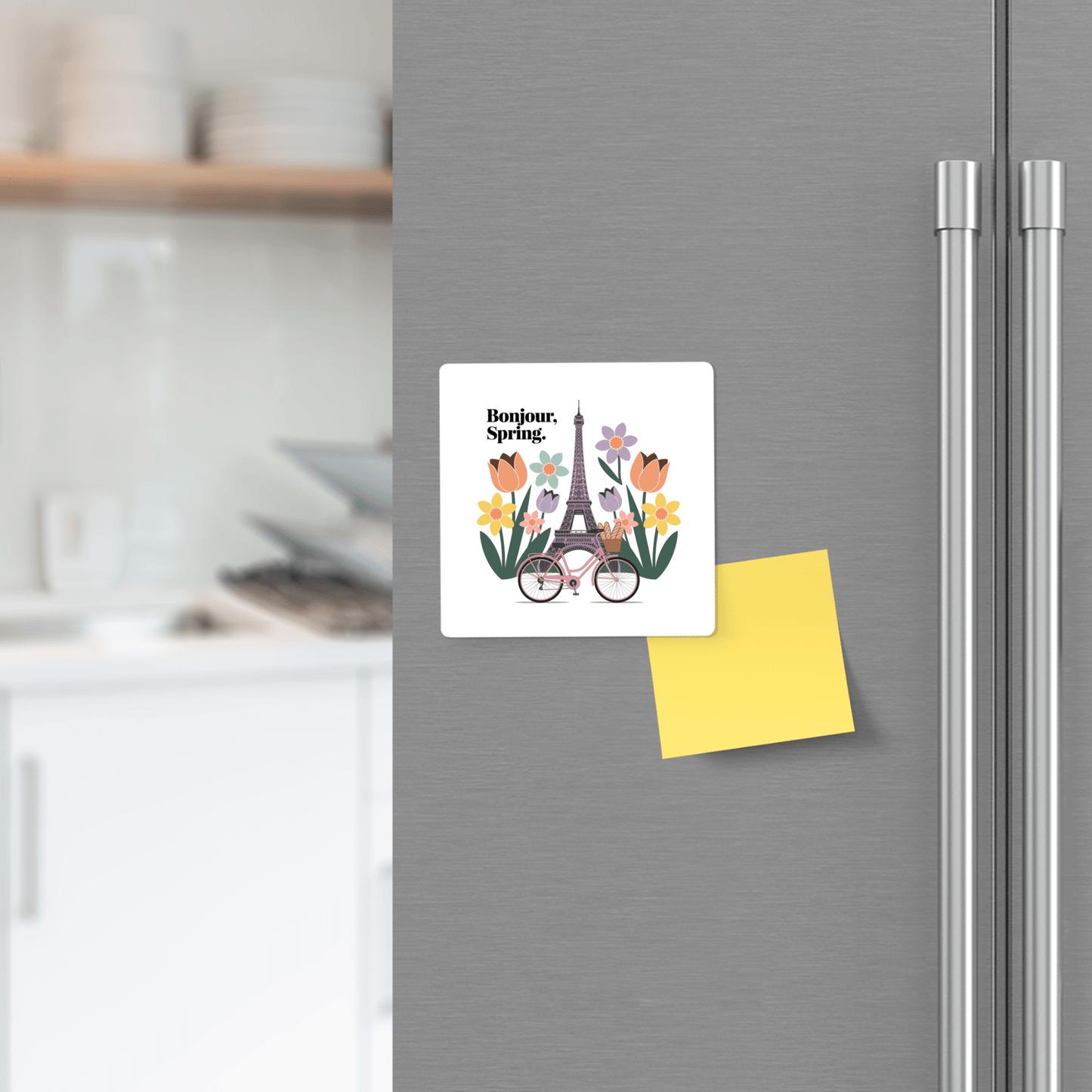 Add Parisian flair to your kitchen with the Bonjour Spring Magnet – Paris Bicycle & Floral Charm by Mirabilia Boutique, shown here on a fridge beside a yellow sticky note—perfect for stylish and charming décor.