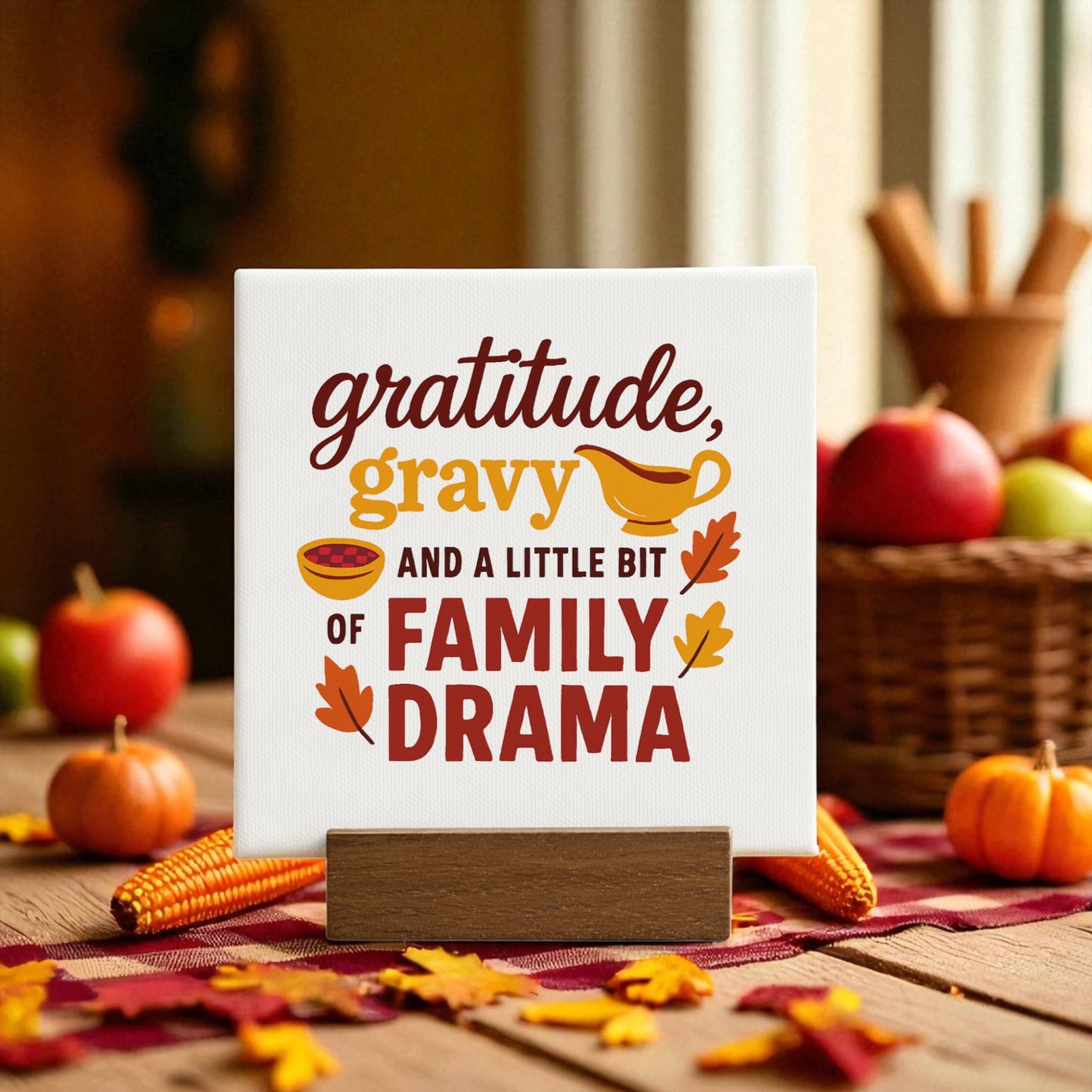 The "Gratitude Gravy & Drama" mini sign by Mirabilia Boutique features autumn leaves and food art, making it a fun Thanksgiving decor piece for any cozy, sunlit space.