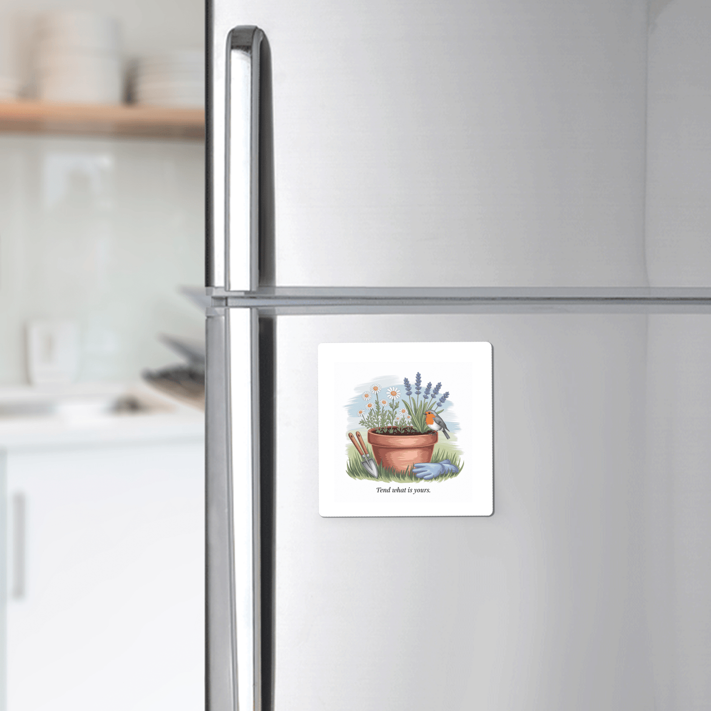 A sleek stainless steel fridge displays the Mirabilia Boutique Tend What Is Yours Magnet—featuring floral art and the quote "Find what is yours"—with a modern kitchen backdrop, making it an ideal inspirational gift.