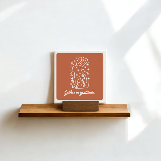 The Mirabilia Boutique "Gather in Gratitude" Mini Canvas Sign – 4x4 Bunny features a white bunny with stars, plants, and the moon—ideal as gratitude decor or shelf art against a white wall.