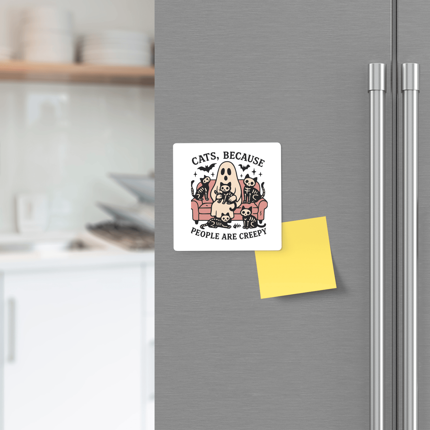A fridge with a yellow sticky note and the Mirabilia Boutique "Funny Ghost Cat Magnet | Cats Because People Are Creepy," featuring a ghost-costumed person on a couch with cats.
