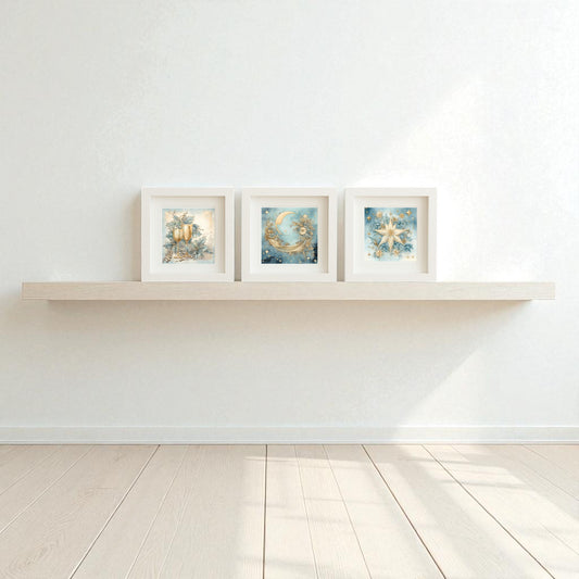 A minimalist room with a light wooden floor and white walls features the Goblet, Moon & Star Holiday Trio—5x5 celestial Christmas shadowboxes by Mirabilia Boutique—whimsical blue and gold art for winter décor.