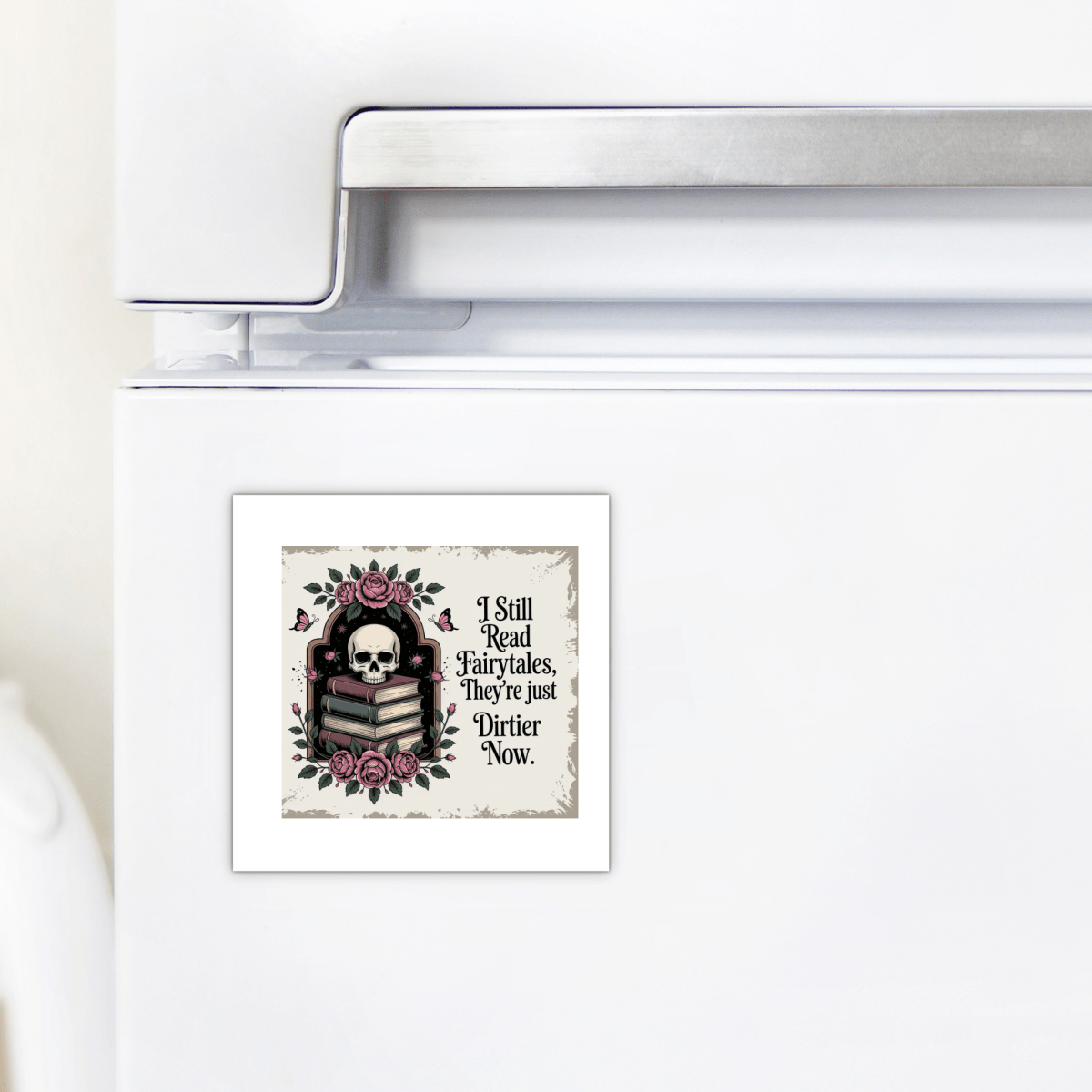 The I Still Read Fairytales Gothic Book Magnet by Mirabilia Boutique features a striking design of a skull, roses, stacked books, and the phrase: "I still read fairytales. They're just dirtier now." This unique literary gift adds whimsical fairytale decor to your kitchen refrigerator.