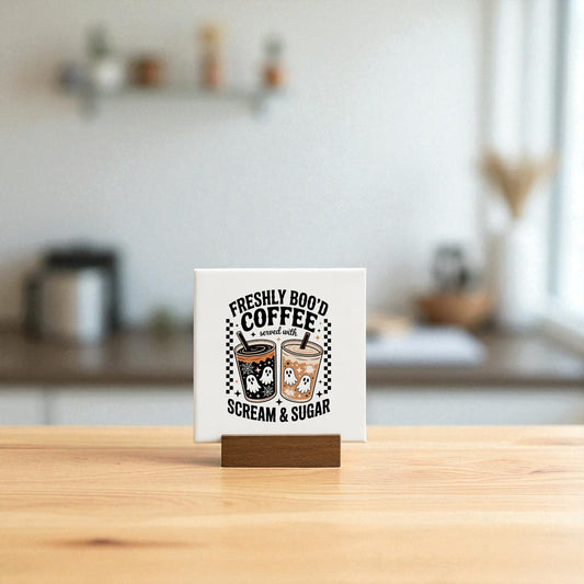 The Mirabilia Boutique Halloween Coffee Bar Sign, Freshly Boo’d Coffee, is a mini 4x4 ceramic tile showing two ghost coffee cups and the phrase "Freshly Boo’d Coffee served with Scream & Sugar"—perfect spooky decor for your coffee bar.