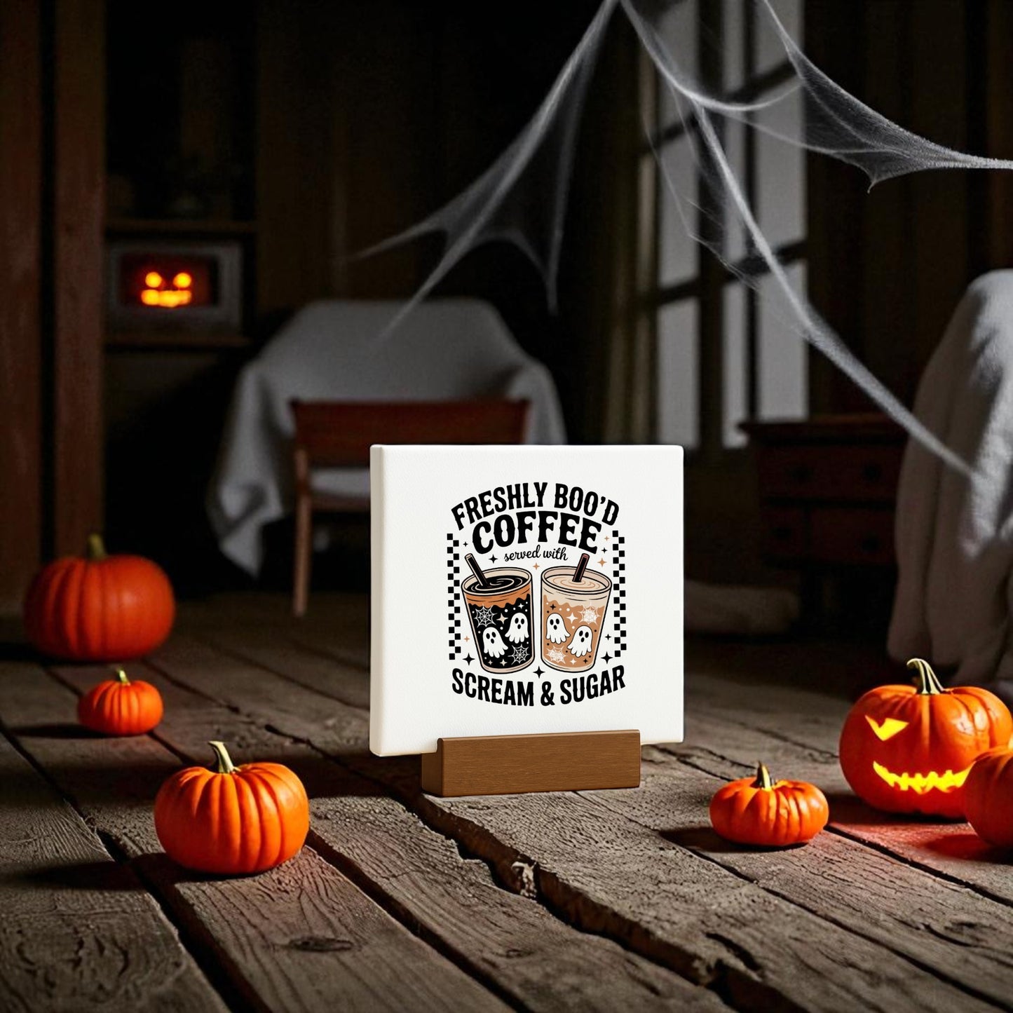 A Halloween-themed room features Mirabilia Boutique’s Mini 4x4 "Freshly Boo’d Coffee" Halloween Coffee Bar Sign, surrounded by small pumpkins, a jack-o’-lantern, fake cobwebs, and charming ghost coffee decor.