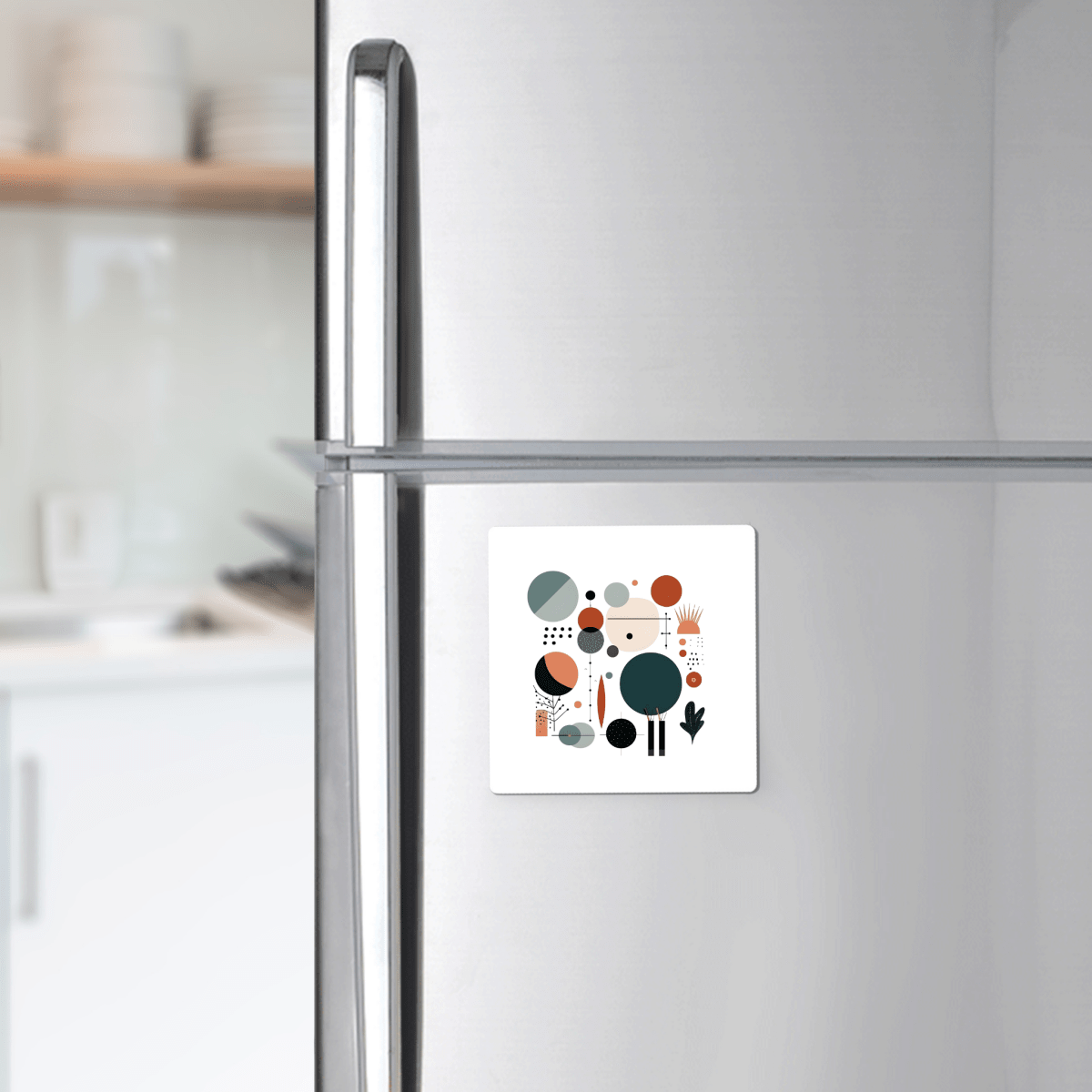 A stainless steel refrigerator displays the Harvest Sun Mid Century Modern Magnet by Mirabilia Boutique, featuring colorful abstract shapes—a striking accent for warm fall décor in a modern kitchen with white cabinets and shelves.