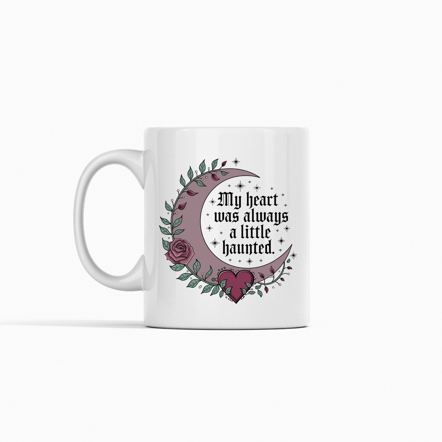 The Gothic Mug | My Heart Was Always a Little Haunted by Mirabilia Boutique features a crescent moon, roses, leaves, a heart, and stars on a white background, with the gothic phrase, "My heart was always a little haunted.