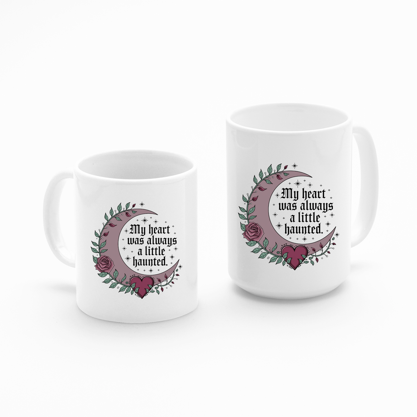 Set of two white Mirabilia Boutique Gothic Mugs featuring crescent moons, roses, leaves, and stars with the gothic phrase “My heart was always a little haunted.” Perfect for dark romance lovers.