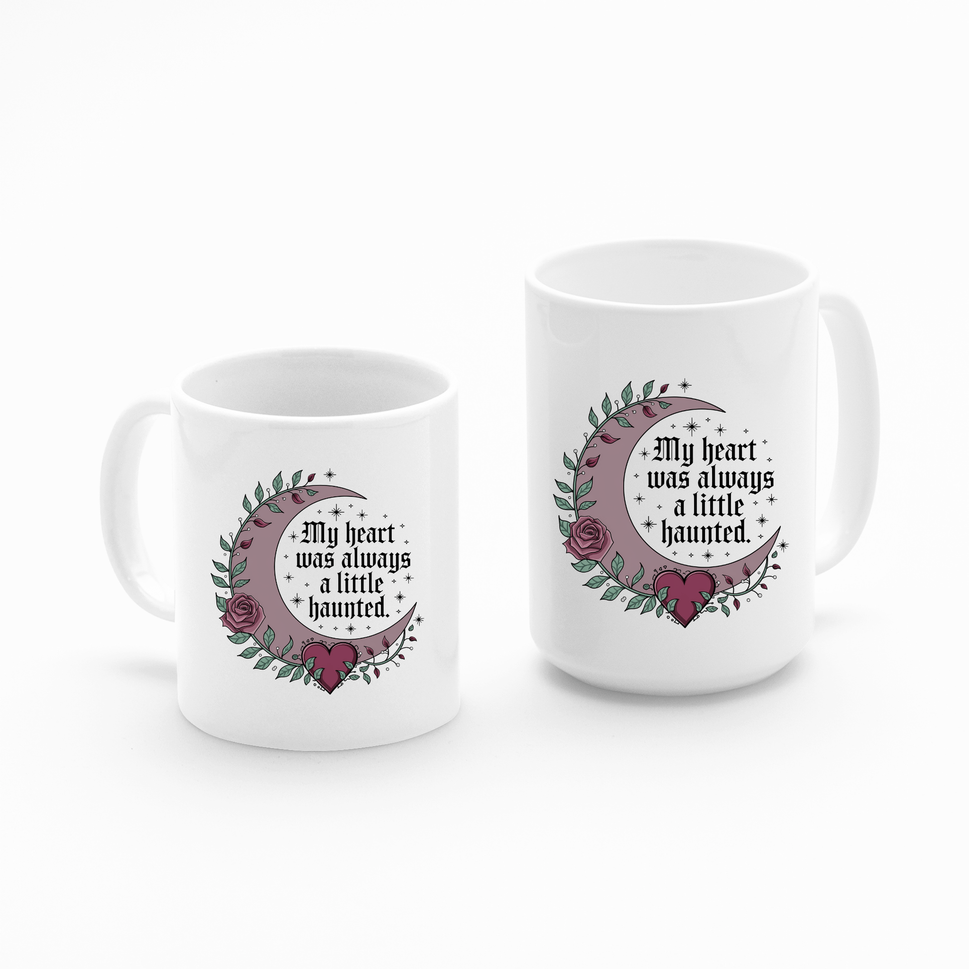 Set of two white Mirabilia Boutique Gothic Mugs featuring crescent moons, roses, leaves, and stars with the gothic phrase “My heart was always a little haunted.” Perfect for dark romance lovers.