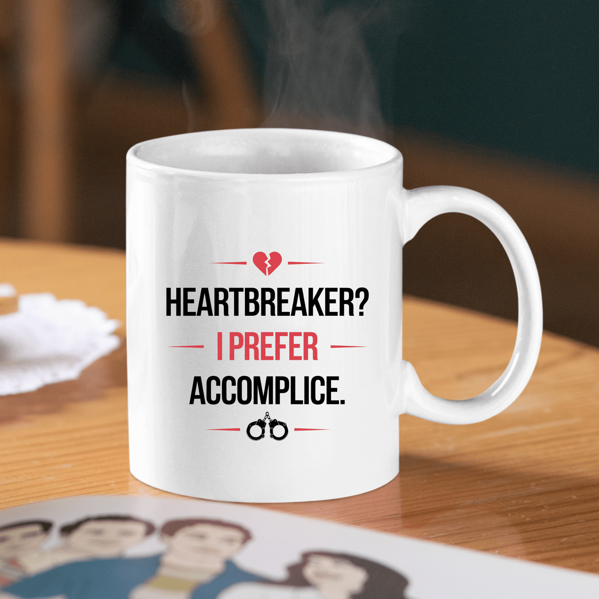 The Mirabilia Boutique Heartbreaker Mug features bold black and red text—“HEARTBREAKER? I PREFER ACCOMPLICE”—with a broken heart and handcuff design, making it a flirty Valentine gift for playful couples.