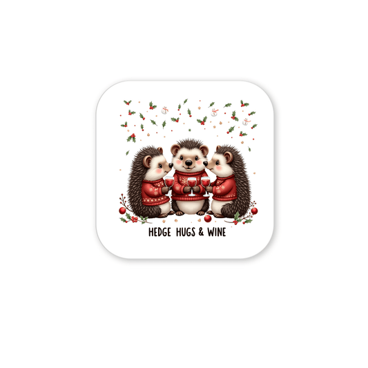 The Mirabilia Boutique Hedge Hugs & Wine Magnet features three hedgehogs in red sweaters with wine glasses, festive holly, and "Hedge Hugs & Wine" text—a funny holiday gift for wine lovers.
