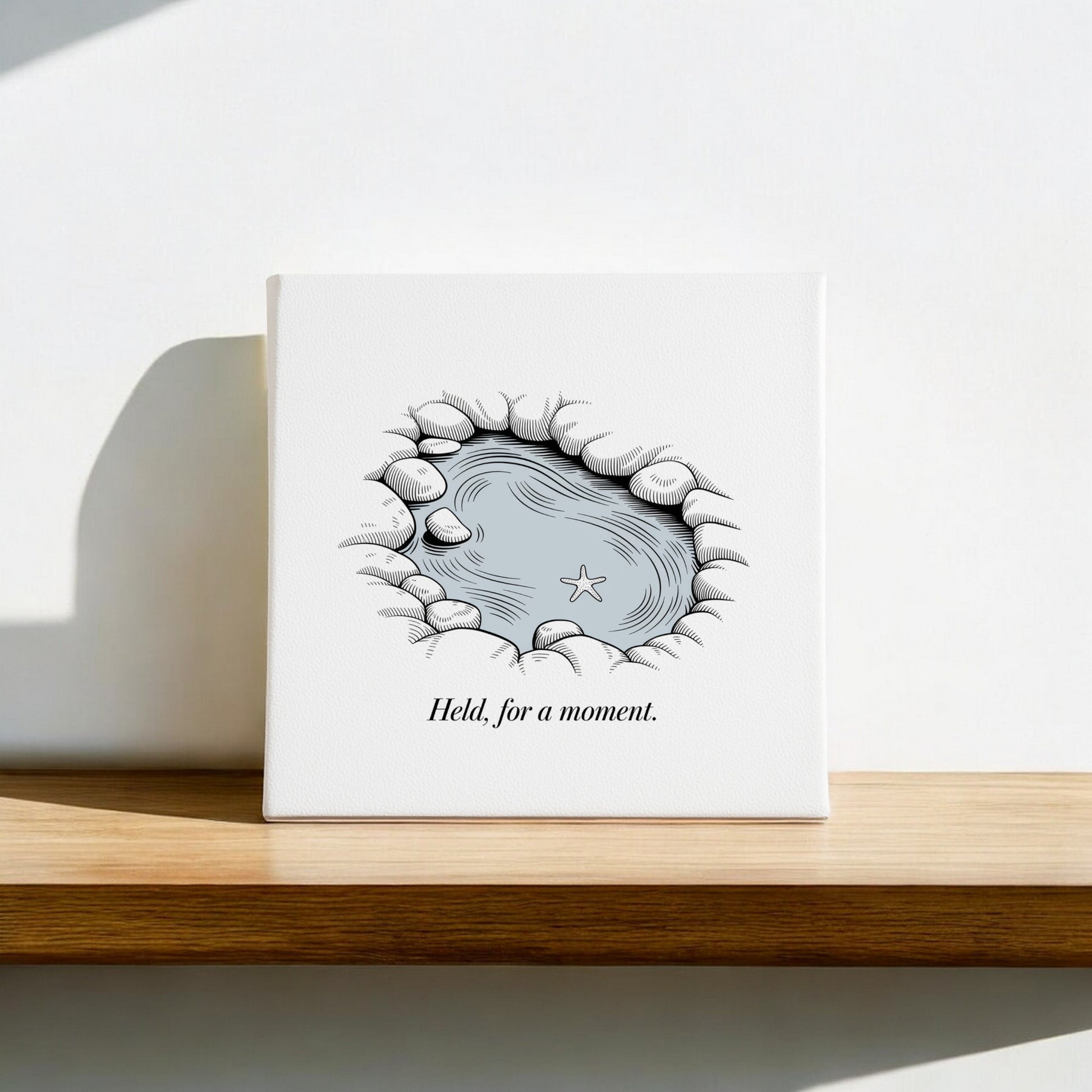 The "Held, For a Moment – 8x8 Coastal Canvas Wall Art" by Mirabilia Boutique features a tidepool scene with rocks and a starfish, plus the text: "Held, for a moment." A calm, coastal accent for any home.
