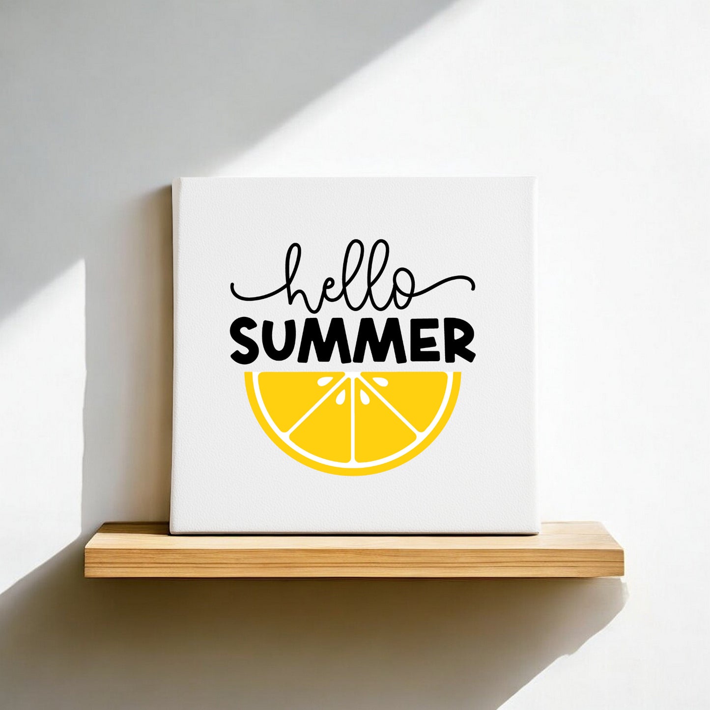 The Mirabilia Boutique Hello Summer Lemon Canvas Sign – 8x8 Wall Art sits on a wooden shelf, with “hello SUMMER” above a yellow lemon slice, and sunlight casting a shadow—an ideal touch for your summer home decor.