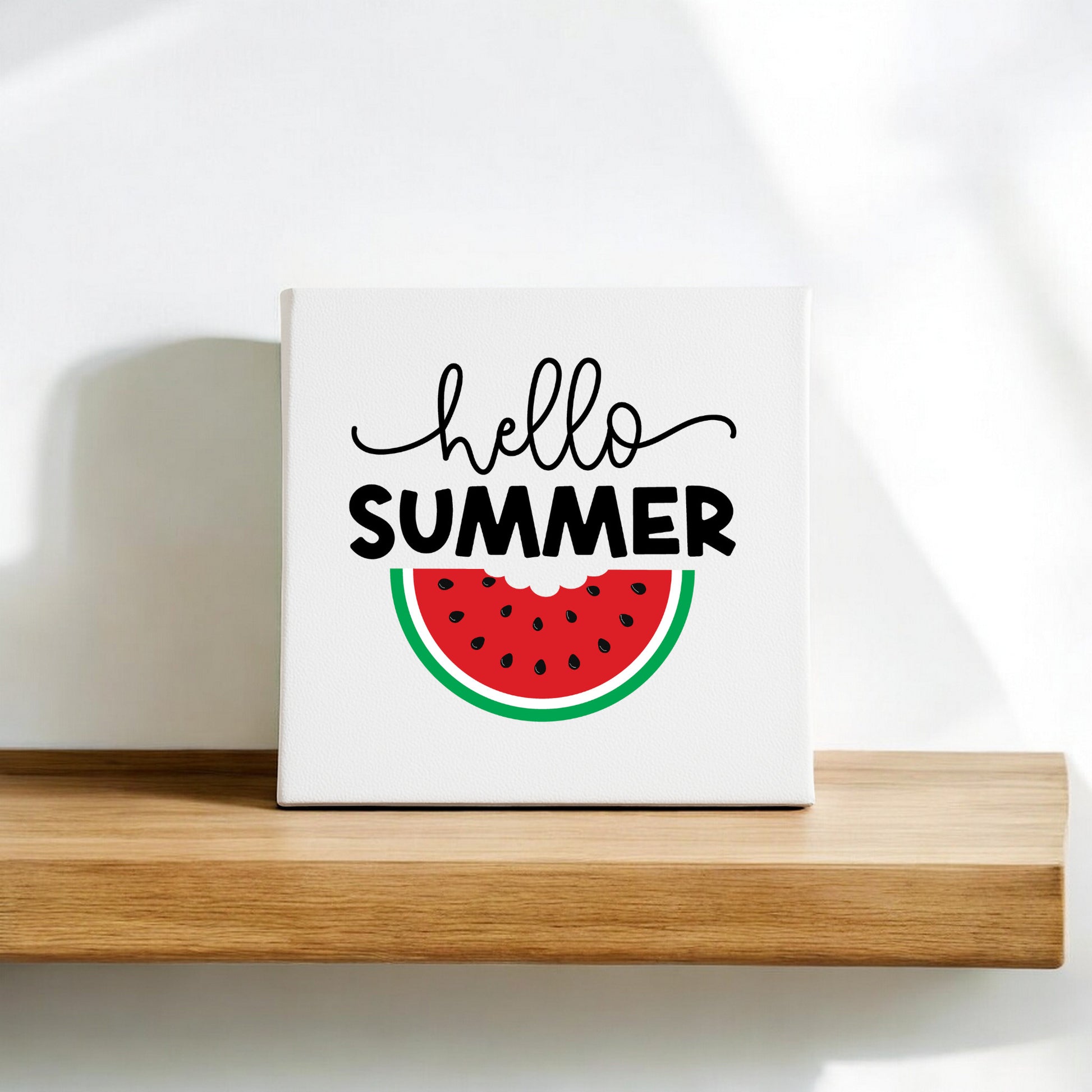 The Hello Summer Watermelon Canvas Sign by Mirabilia Boutique is an 8x8 fruit wall art piece featuring "hello SUMMER" and a watermelon slice—ideal for adding a cheerful, seasonal touch to your space.