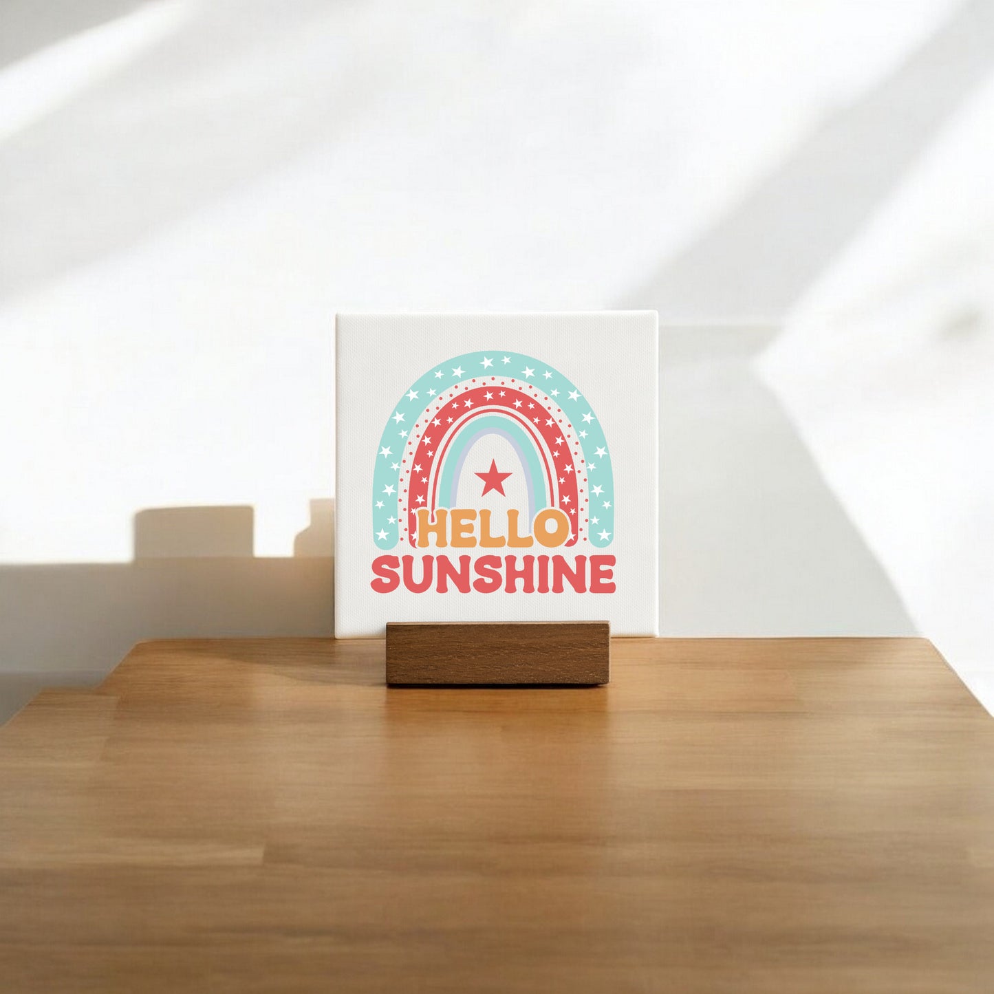 The Mirabilia Boutique Hello Sunshine Mini Canvas Sign with Stand features a pastel rainbow and star design, bold orange "HELLO SUNSHINE" text, and comes displayed on a wooden stand—perfect for brightening up any space.