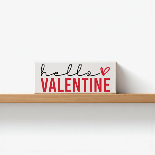 The Mirabilia Boutique Hello Valentine Sign is a modern red and white shelf decor featuring "hello VALENTINE" with a heart, perfect for Valentine’s Day. Its white background adds a romantic touch to your home.