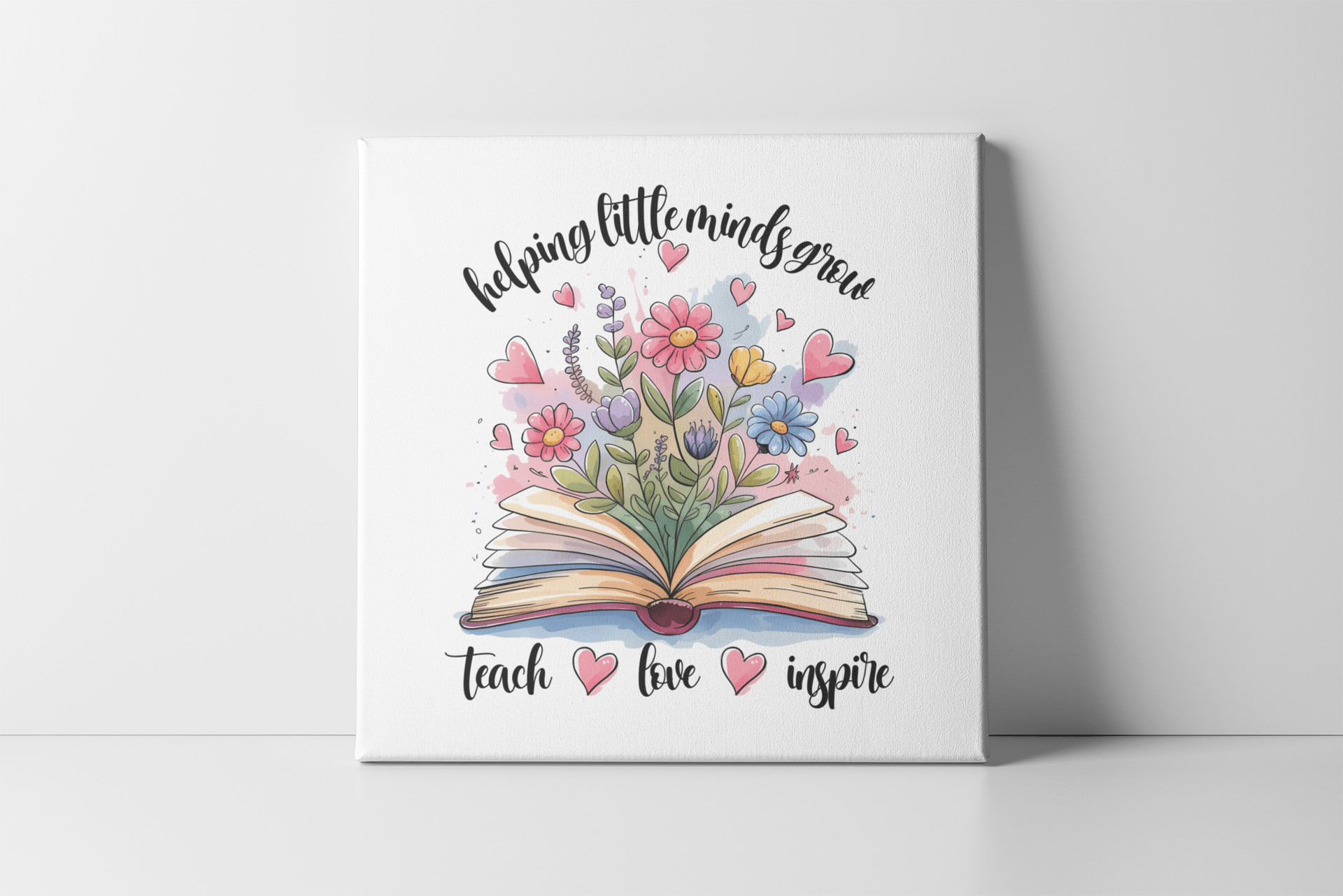 The Mirabilia Boutique Helping Little Minds Grow Mini Canvas with easel features an open book, vibrant hearts and flowers, plus the phrases "helping little minds grow" and "teach, love, inspire"—a perfect decorative teacher gift.