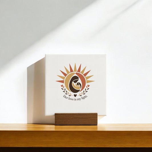 The Her Love Is My Light Mini Sign by Mirabilia Boutique is a white canvas with a sun and mother-child design on a wood stand, perfect as a Mother’s Day keepsake or gift for mom.